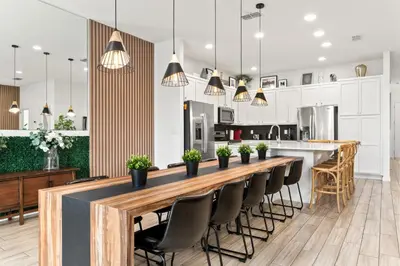 a kitchen with a long wooden bar with black chairs at Fresh Amazing Family Home. Private Pool. Game Room. Sleeps 24 in Kissimmee