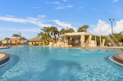 a swimming pool at a resort with a fountain at Fun Family Villa Pool BBQ Near Disney World 5BR in Kissimmee