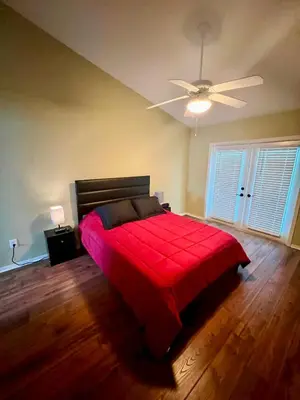 a bedroom with a red bed and a ceiling fan at Grand Villas of Island 3BR Condo near Disney Parks and Universal in Kissimmee