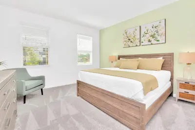 a bedroom with a bed and a desk and a chair at Upstay 9BR Disney Retreat w Pool, BBQ & Hot Tub in Kissimmee