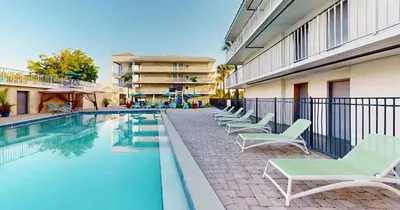 a swimming pool with lounge chairs next to a building at Park Royal Orlando in Kissimmee