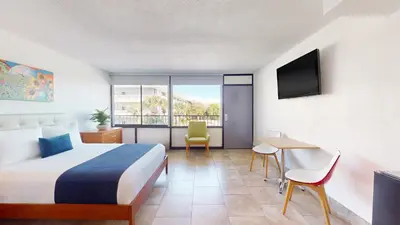 a hotel room with a bed and a desk and a television at Park Royal Orlando in Kissimmee