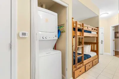 a laundry room with a washer and dryer and a bunk bed at Luxury Condo with Huge Private Balcony on Lake Bryan in Orlando