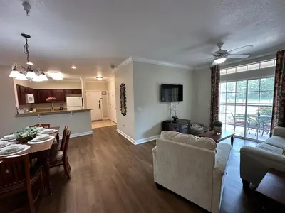 a living room with a dining table and a kitchen at Gone 2 Florida Vacation Homes in Orlando