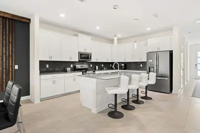 a kitchen with white cabinets and white appliances at Sophisticated 6BR at Storey Lake SL2766 in Kissimmee