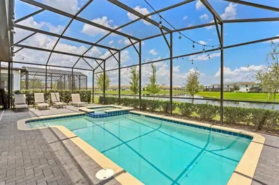 a swimming pool with a glass roof and a patio with lounge chairs at Luxury Decor 6BR at Storey Lake sleeps 16 SL2945 in Kissimmee