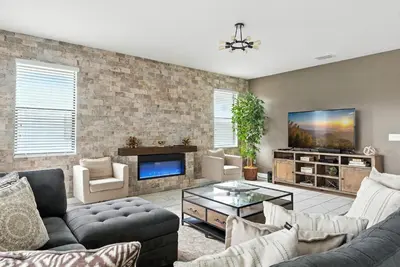 a living room with a couch and a tv at Luxury Decor 6BR at Storey Lake sleeps 16 SL2945 in Kissimmee