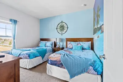 a bedroom with two beds and a clock on the wall at 4BR Community pool across the street WL8989 in Kissimmee