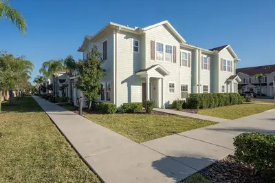 a house on a street with a sidewalk at 4BR Community pool across the street WL8989 in Kissimmee