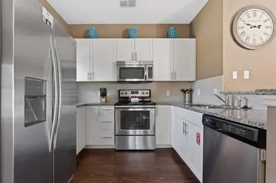 a kitchen with stainless steel appliances and a clock on the wall at Cozy Decor 4BR at West Lucaya Resort WL8972 in Kissimmee