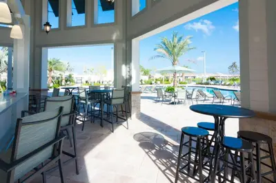 a restaurant with tables and chairs and a pool at Disney Familly Lovers up to 11 SL4928 in Kissimmee