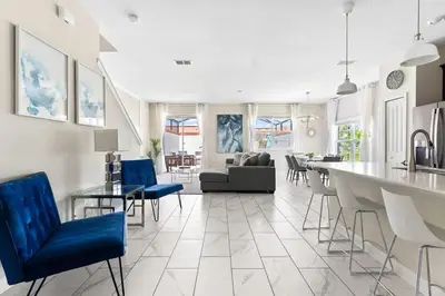 a kitchen and living room with blue chairs at Disney Familly Lovers up to 11 SL4928 in Kissimmee