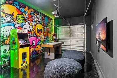 a room with a gaming machine and a colorful wall at 5BR Themed Bedrooms at Storey Lake SL4702 in Kissimmee