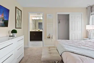 a bedroom with a large bed and a bathroom at Cute with Private Pool at Storey Lake SL4802 in Kissimmee