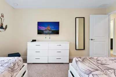 a bedroom with a white dresser and a mirror at Cute with Private Pool at Storey Lake SL4802 in Kissimmee