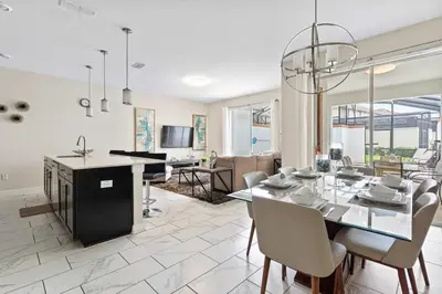 a dining room and living room with a table and chairs at Cute with Private Pool at Storey Lake SL4802 in Kissimmee