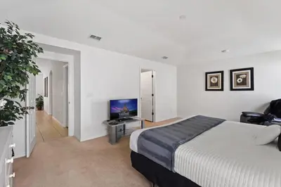 a bedroom with a bed and a flat screen tv at Ground floor spacious house 4BR VP2512 in Kissimmee