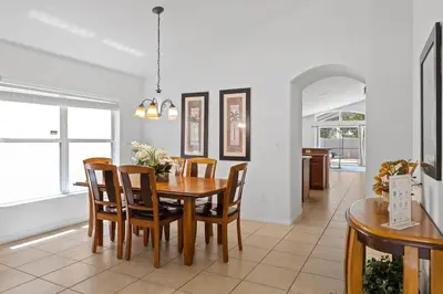 a dining room with a wooden table and chairs at Ground floor spacious house 4BR VP2512 in Kissimmee