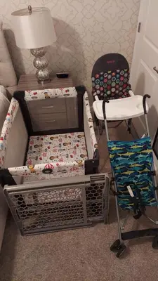 a room with a crib and a chair and a lamp at 4 BR Bright Cozy at Storey Lake SL3113 in Kissimmee