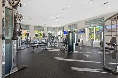 a gym with several treadmills and elliptical machines at 4 BR Bright Cozy at Storey Lake SL3113 in Kissimmee