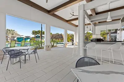 a patio with tables and chairs and a view of the ocean at 4 BR Bright Cozy at Storey Lake SL3113 in Kissimmee