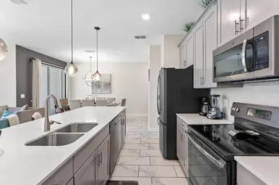 a kitchen with white counter tops and a black refrigerator at Family Friendly Home 4BR Private Pool SL4823 in Kissimmee