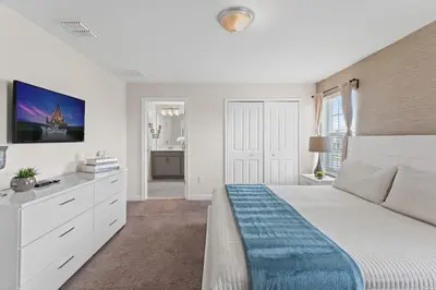 a white bedroom with a large bed and a tv at Family Friendly Home 4BR Private Pool SL4823 in Kissimmee