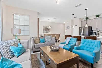 a living room with blue furniture and a kitchen at Family Friendly Home 4BR Private Pool SL4823 in Kissimmee