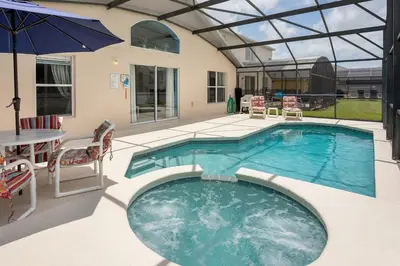 a swimming pool with a table and an umbrella at 4 BR No carpet Just Remodeled Unit SR1205 in Kissimmee