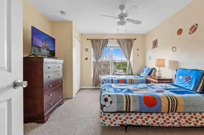 a bedroom with a bed and a dresser with a tv at Relaxing 3BR Haven for 8 at Seven Dwarfs SD2610 in Kissimmee