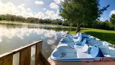 a row of boats parked at a dock on a lake at Relaxing 3BR Haven for 8 at Seven Dwarfs SD2610 in Kissimmee