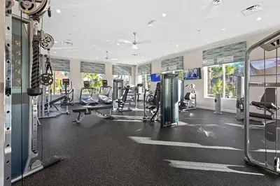 a gym with several treadmills and cardio machines at 2 BR Modern Apt near Disney SL4741 in Kissimmee