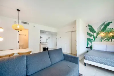 a living room with a blue couch and a table at Studio near Universal Studios with great view in Orlando