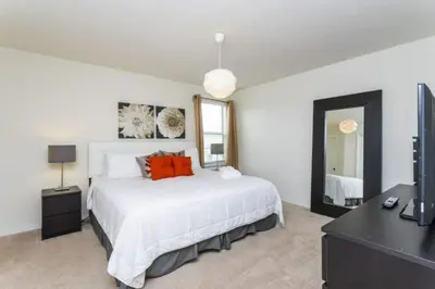a bedroom with a large white bed with orange pillows at 4572 Perfect home for your family close to all parks in Kissimmee