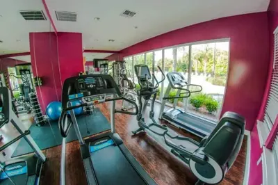 a gym with a bunch of cardio machines in it at 5372 Lovely home inside Disney area in Kissimmee