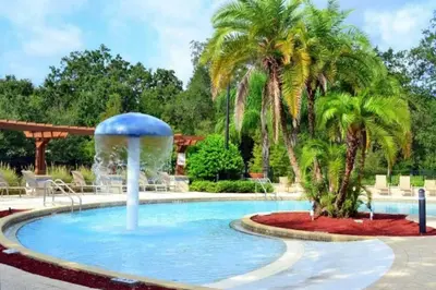 a pool with a fountain and palm trees at 5372 Lovely home inside Disney area in Kissimmee