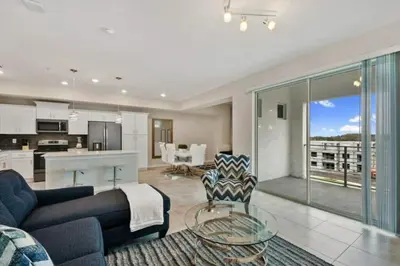 a living room with a blue couch and a kitchen at 3120 BRAND NEW stunning apartment in Kissimmee