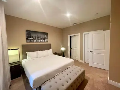 a bedroom with a large white bed and a door at Home in Orlando 7 Min from Disney Parks and 20 from Universal - Sleeps 8! 4 bedrooms each with a private bathroom in Orlando