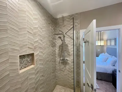 a bathroom with a shower and a bed at Home in Orlando 7 Min from Disney Parks and 20 from Universal - Sleeps 8! 4 bedrooms each with a private bathroom in Orlando