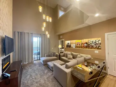 a living room with a couch and a tv at Home in Orlando 7 Min from Disney Parks and 20 from Universal - Sleeps 8! 4 bedrooms each with a private bathroom in Orlando