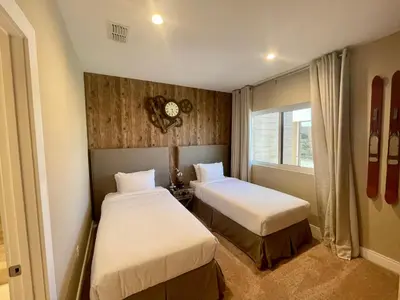 a bedroom with two beds and a clock on the wall at Home in Orlando 7 Min from Disney Parks and 20 from Universal - Sleeps 8! 4 bedrooms each with a private bathroom in Orlando