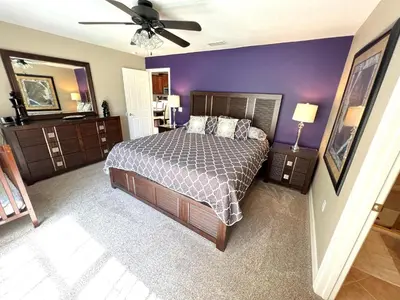 a bedroom with a bed and a ceiling fan at Mickeys Escape - Magical Lakeview 7BR - 4 Master Suites Pool & Hot Tub BBQ Home Theater and 2 Miles Disney! in Orlando
