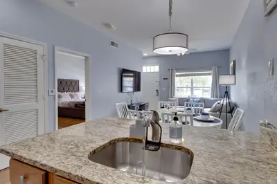 a kitchen with a sink and a living room at 12 Mi to Disney Family Home with Resort Amenities! in Kissimmee