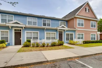 a house with a white fence in front of it at 12 Mi to Disney Family Home with Resort Amenities! in Kissimmee