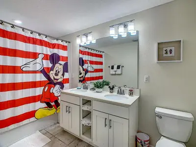 a bathroom with a american flag shower curtain and a sink at Luxury Brand NEW 2 bedroom apt near DISNEY! in Kissimmee
