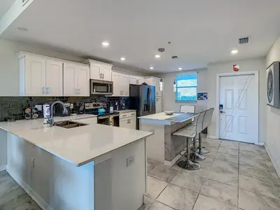 a kitchen with white cabinets and a counter top at Luxury Brand NEW 2 bedroom apt near DISNEY! in Kissimmee