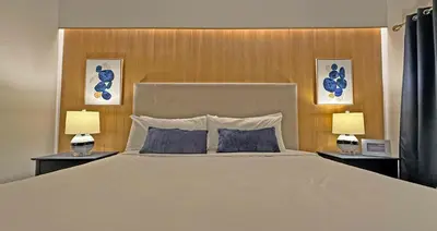 a bedroom with a large white bed with two lamps at Villas at Seven Dwarfs Resort - Near to Disney in Kissimmee