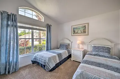 two beds in a bedroom with a window at Pool and Lanai Emerald Isle Resort Home! in Kissimmee