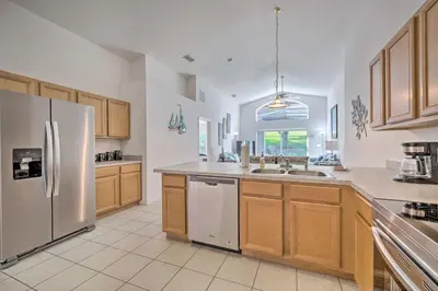 a large kitchen with wooden cabinets and stainless steel appliances at Pool and Lanai Emerald Isle Resort Home! in Kissimmee