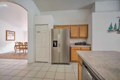 a kitchen with a stainless steel refrigerator and wooden cabinets at Pool and Lanai Emerald Isle Resort Home! in Kissimmee